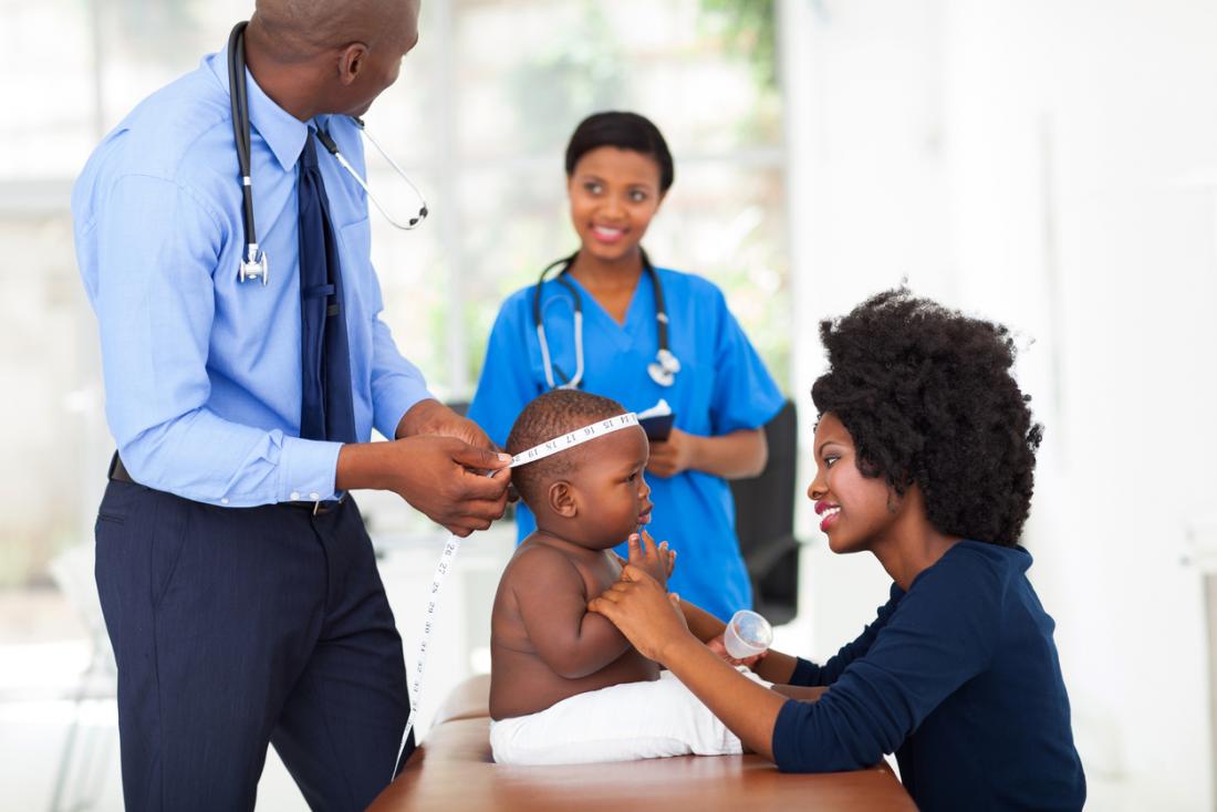 Baby having it's head being measured by pediatrician.