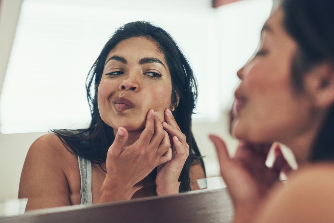 uma mulher olhando acne na bochecha. 