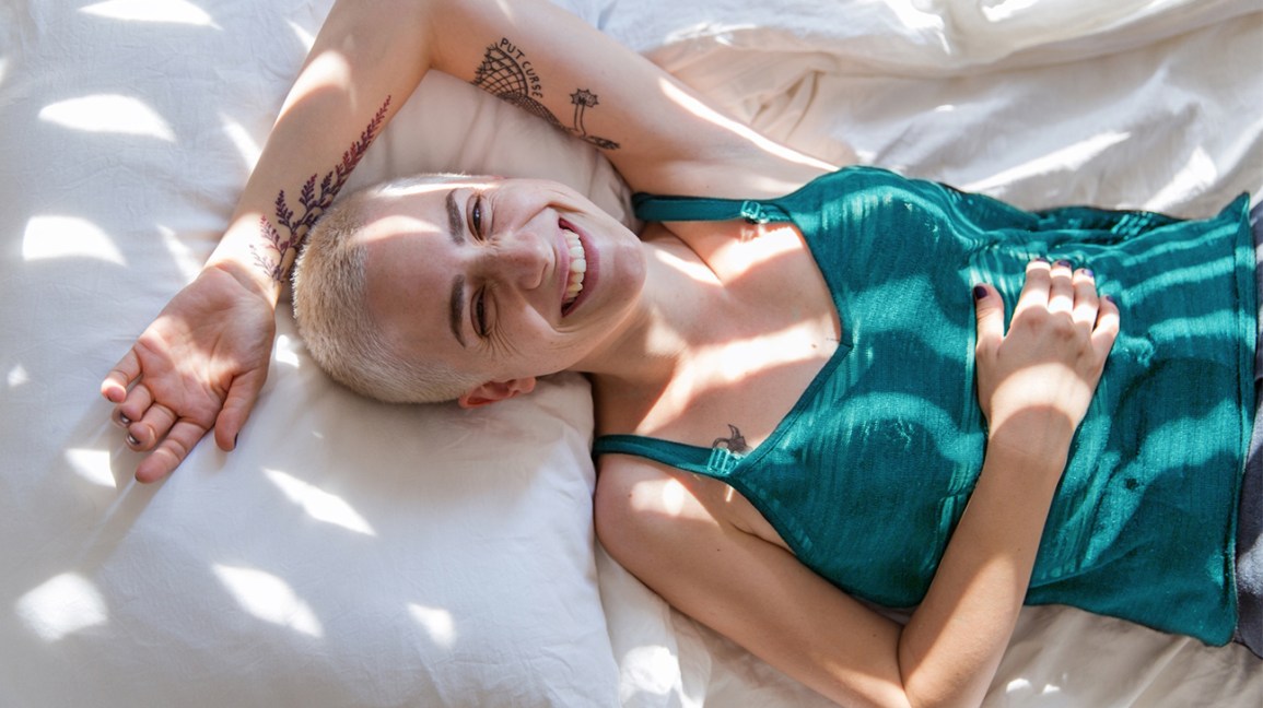 mulher sorrindo acordada na cama