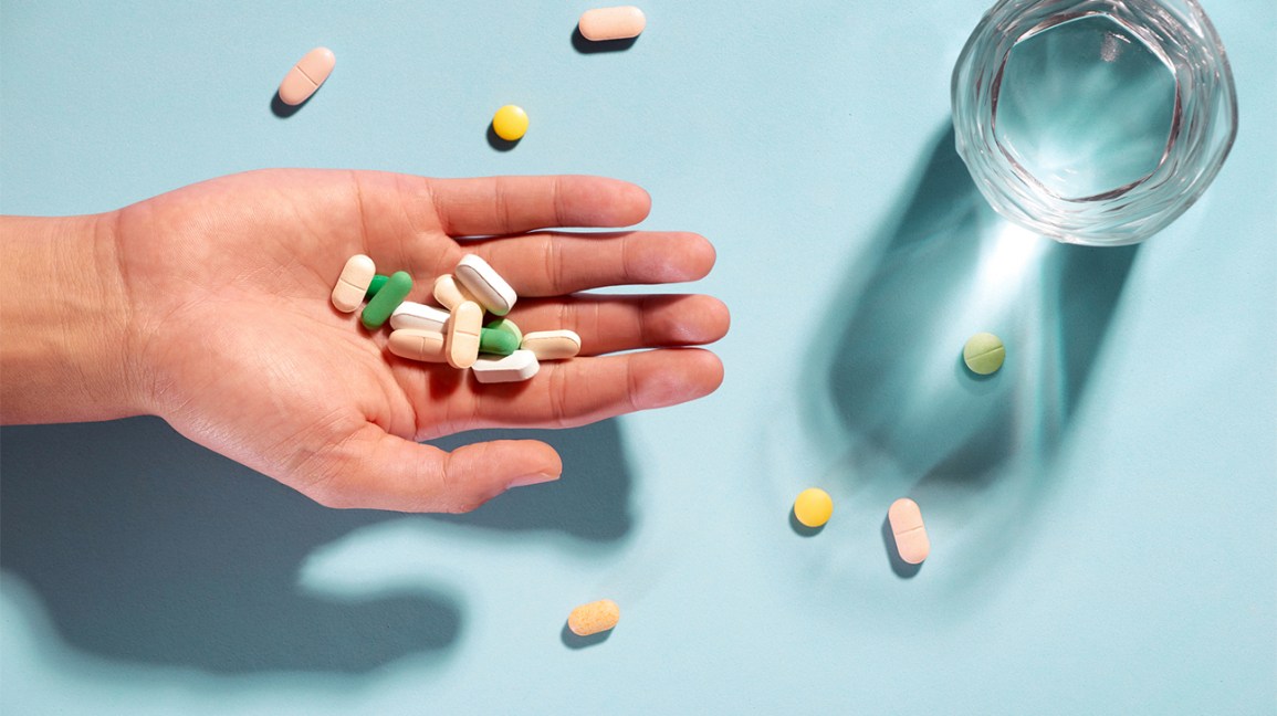 pílulas e suplementos variados na palma da mão aberta