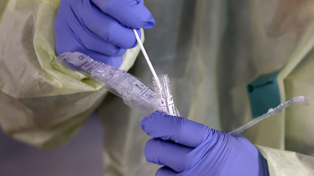 um profissional médico que armazena um cotonete usado para testes de coronavírus