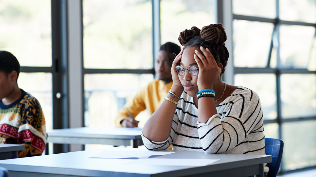 uma menina lutando para se concentrar na sala de aula, pois ela tem distúrbio do processamento sensorial